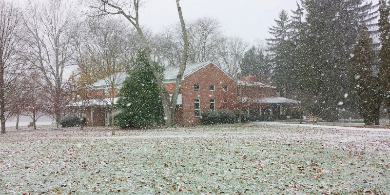Snowy scene around red brick meetinghouse